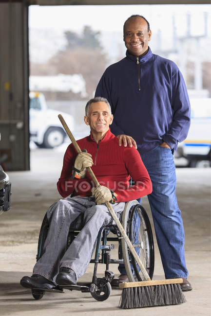 Maintenance technicians, one with a spinal cord injury, cleaning in utility truck garage at Electric Power Plant — Stock Photo