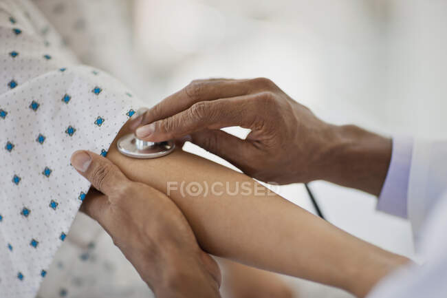 Doctor placing a stethoscope on the inside of a patient elbow to listen to their heartbeat — Fotografia de Stock