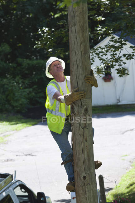 Lineman climbing a pole for installation — Stock Photo