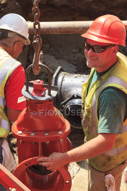 Operatori edili che si preparano a sollevare la valvola a saracinesca per acqua principale — Foto stock