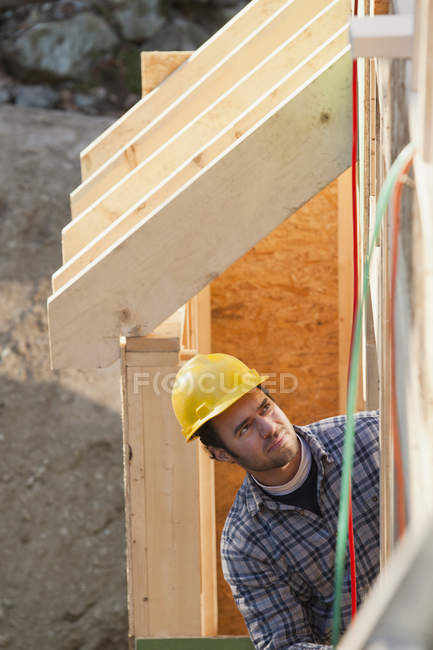 Carpenter reviewing exterior framing of a house — Stock Photo