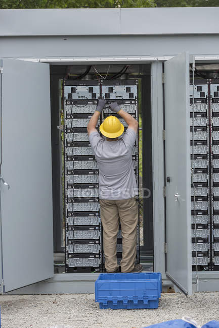 Ingénieur connectant des batteries de stockage d'énergie pour une alimentation de secours à une centrale électrique — Photo de stock