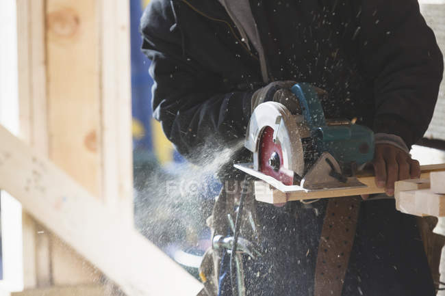 Carpenter using a circular saw, cropped image — Stock Photo