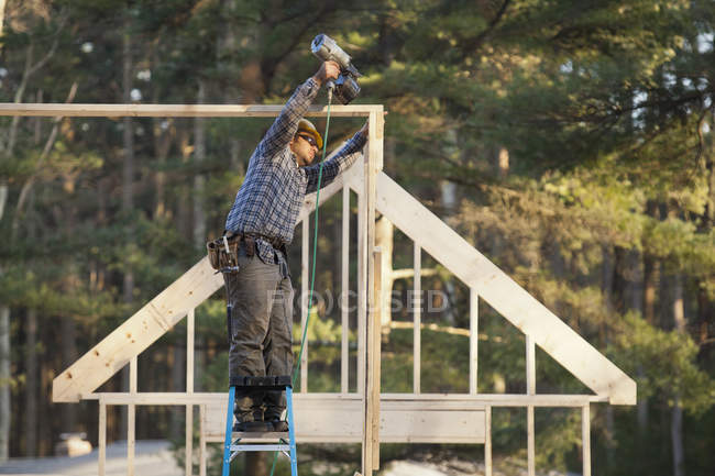 Tischler nagelt Dachkonstruktion für Hausbau — Stockfoto
