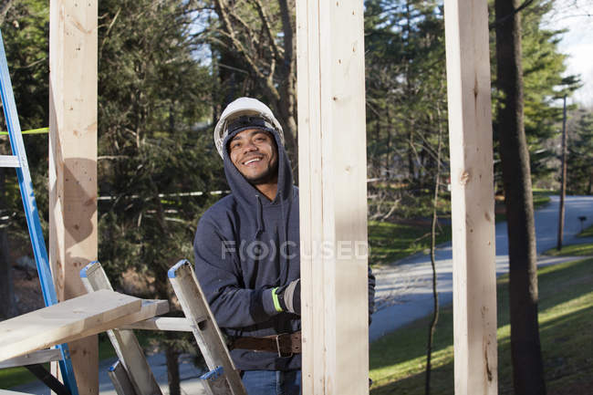 Carpenter climbing ladder to upper level — Stock Photo