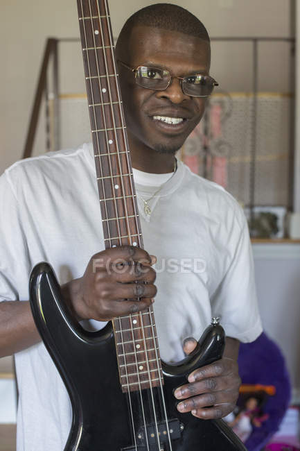 Jeune homme avec le syndrome de Williams jouant de sa guitare électrique — Photo de stock