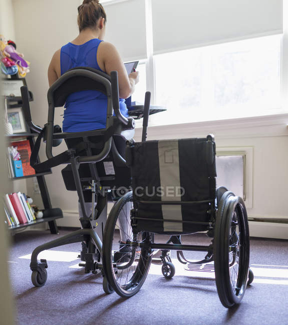 Frau mit Querschnittslähmung arbeitet zu Hause am Stehpult — Stockfoto