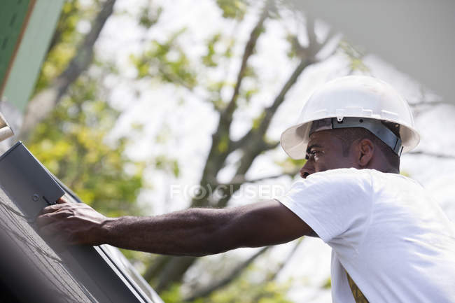 Carpenter placing flashing around skylight on the roof — Stock Photo