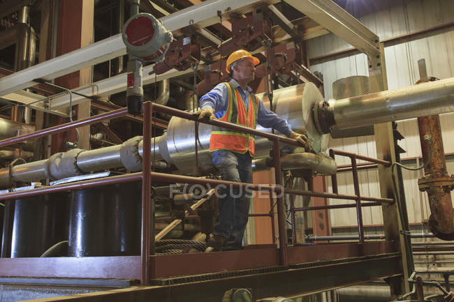 Engineer in electric power plant inspecting condenser room piping — Stock Photo