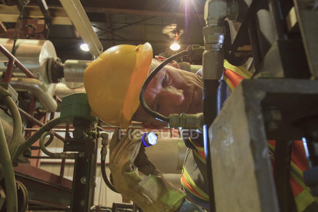 Engineer in electric power plant inspecting a electrically controlled valve — Stock Photo