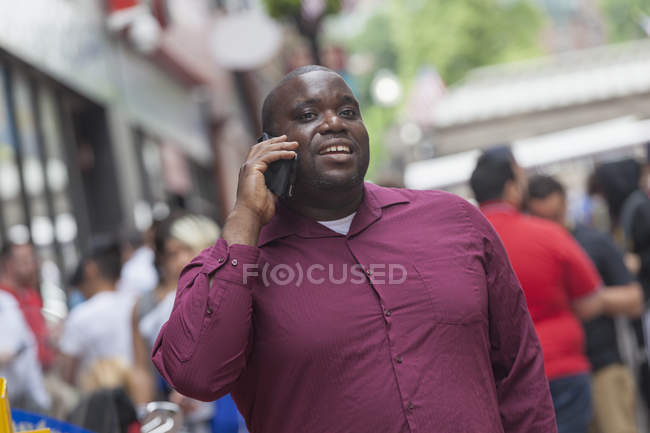 Man with ADHD talking on a mobile phone on city street — Stock Photo