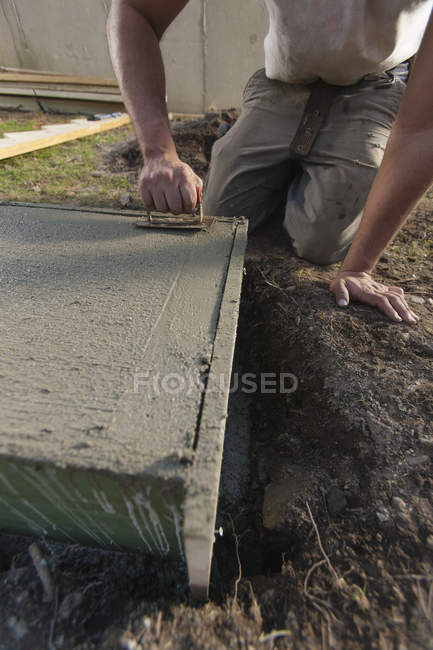 Латиноамериканский плотник, использующий лопатку, чтобы шероховатость лестницы опоры бетона — стоковое фото