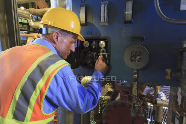 Ingegnere nella centrale elettrica per la revisione delle letture dei sensori — Foto stock