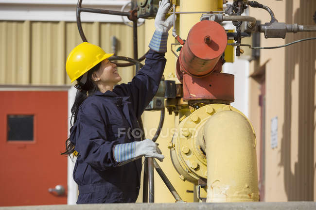 Ingeniera de potencia femenina verificando sensores de línea de combustible en planta eléctrica - foto de stock