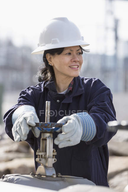 Female power engineer adjusting water valves at power plant — Stock Photo