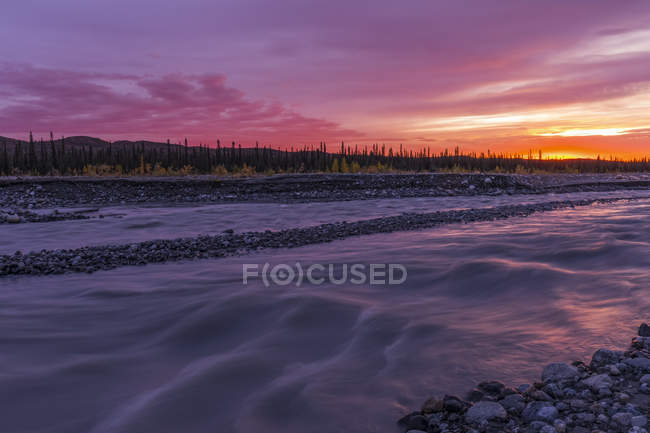Sonnenuntergang über dem schlammigen Fluss im Denali Nationalpark und Naturschutzgebiet; alaska, vereinigte Staaten von Amerika — Stockfoto