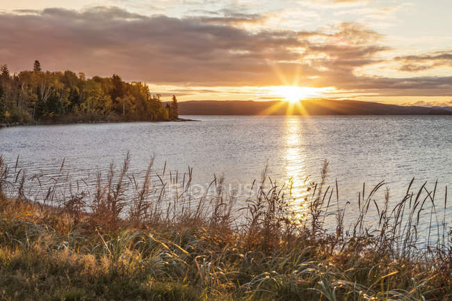 Tranquil Lake Superior and осінні кольори на заході сонця; Онтаріо, Канада — стокове фото