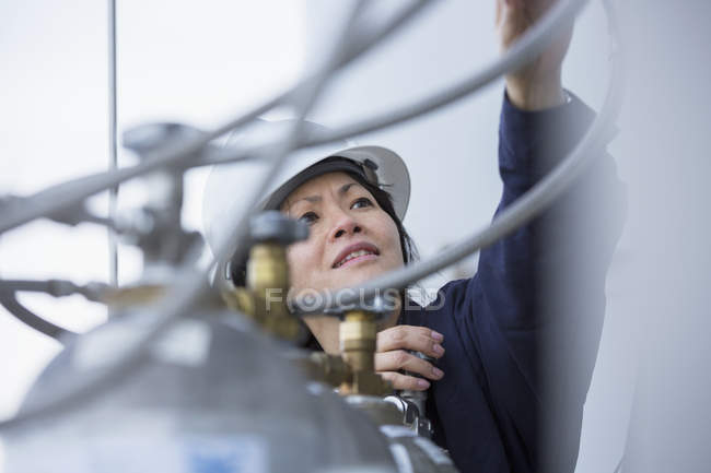 Ingénieur de puissance femelle vérifiant les injecteurs avec du gaz comprimé à la centrale — Photo de stock