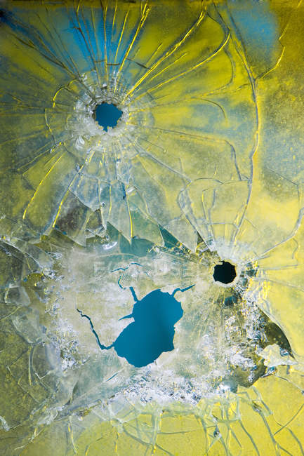 Пулевые отверстия в разбитом стекле — стоковое фото