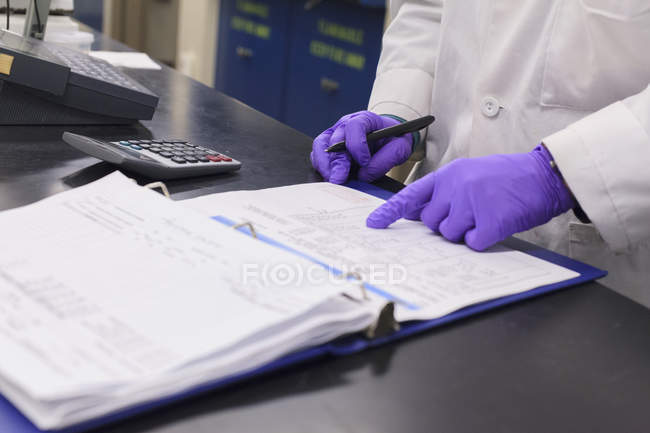 Lab technician recording data from sample test — Stock Photo