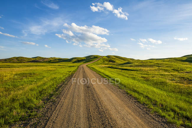 Estrada de cascalho que leva à distância, Parque Nacional de Gramados; Val Marie, Saskatchewan, Canadá — Fotografia de Stock