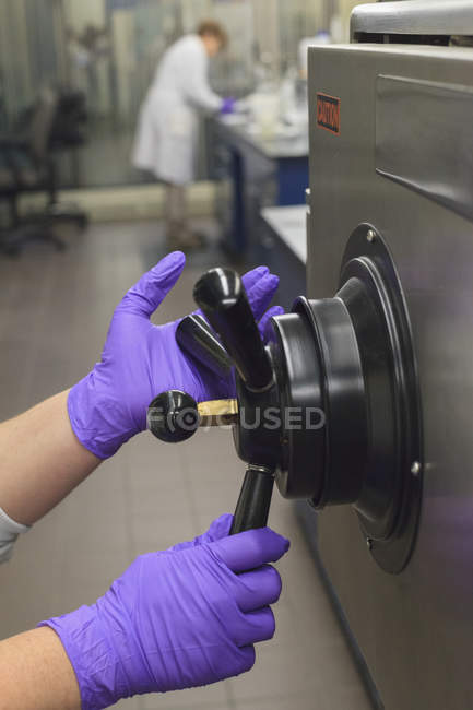 Lab technician opening sterilization tank — Stock Photo