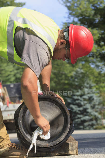 Travailleur de la construction préparant conduite d'eau pour l'installation — Photo de stock