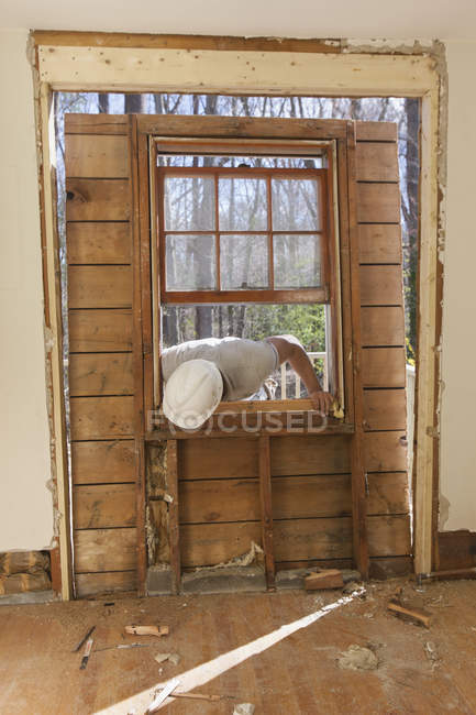 Латиноамериканский плотник удаляет недавно вырезанную дверь из дома на палубе — стоковое фото