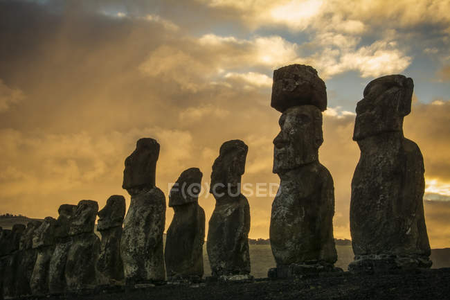 Os quinze moais de Tongariki close-up em perspectiva decrescente contra um nascer do sol colorido; Ilha de Páscoa, Chile — Fotografia de Stock
