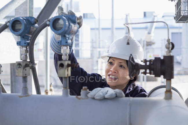 Female power engineer checking pressure transducers at power plant — Stock Photo