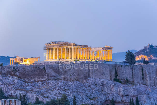 Antiguas ruinas de la Acrópolis de Atenas iluminadas al atardecer; Atenas, Grecia - foto de stock