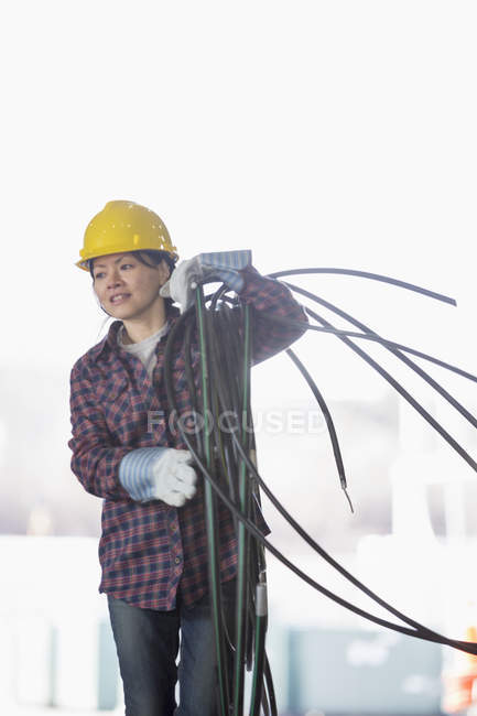 Energietechnikerin mit Stromkabel — Stockfoto