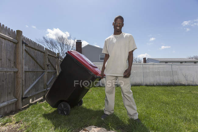 Людина з синдромом Вільямса виносить сміття. — стокове фото