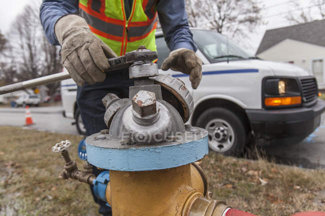 Imagem cortada do técnico do departamento de água que fecha o hidrante do fogo para nivelar tubulações de água — Fotografia de Stock