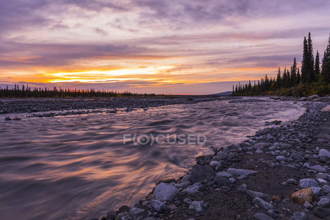 Закат над грязной рекой в национальном парке Денали и Пресерве; Аляска, Соединенные Штаты Америки — стоковое фото