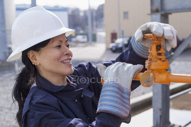 Female power engineer checking valve at power station — Stock Photo