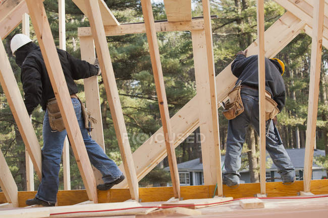 Carpenters moving boards at upper level — Stock Photo