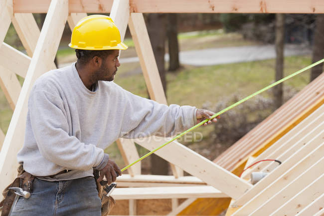 Carpenter measuring the length on dormer — Stock Photo