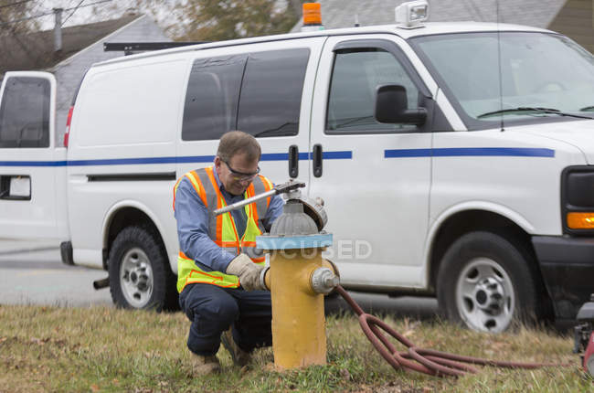 Техник водного департамента устанавливает колпачки на пожарный гидрант — стоковое фото