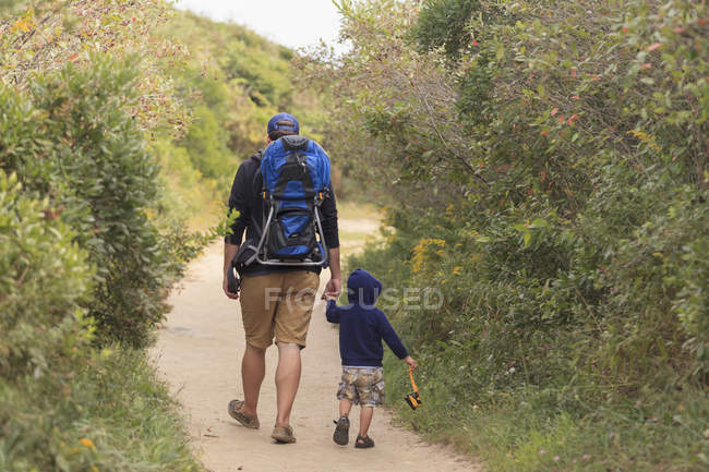 Вид сзади на человека, идущего со своим сыном — стоковое фото