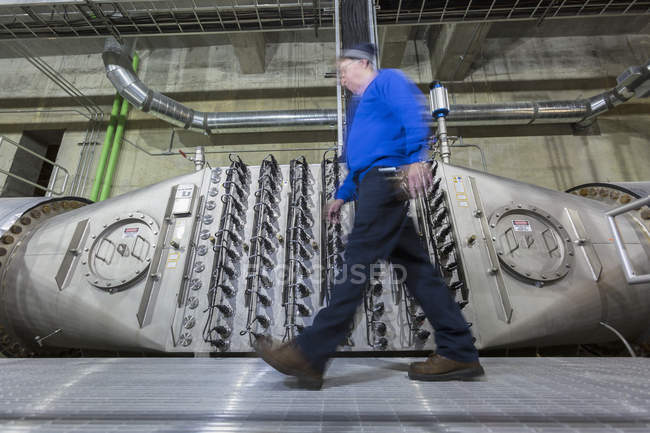 Engenheiro andando por estação de tratamento de água sala de tratamento de ionização ultravioleta — Fotografia de Stock