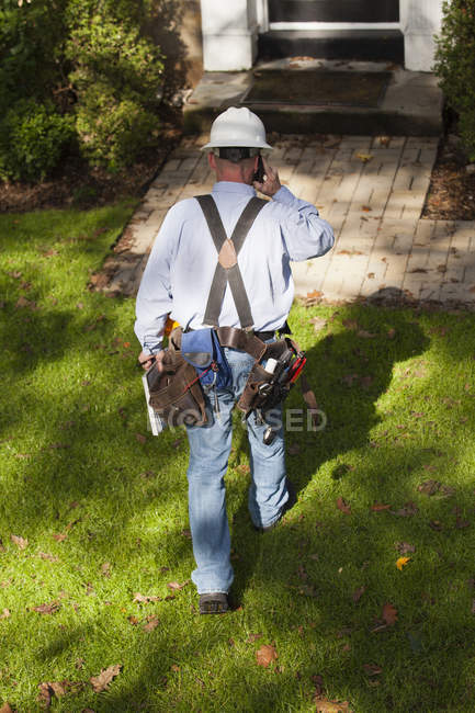 Cable installer on cell phone preparing to enter home for installation — Stock Photo
