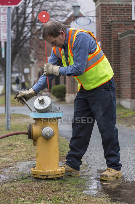 Technicien du service de l'eau installant un pieu de neige — Photo de stock