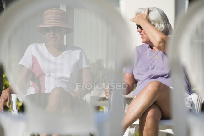 Dos mujeres mayores sentadas en sillas en un complejo turístico - foto de stock