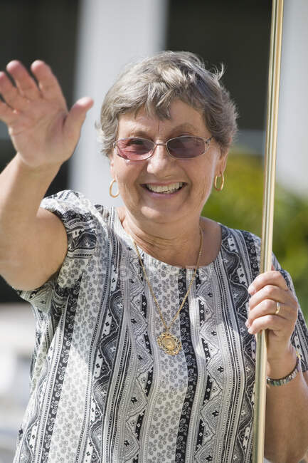Senior mulher jogando shuffleboard e sorrindo — Fotografia de Stock