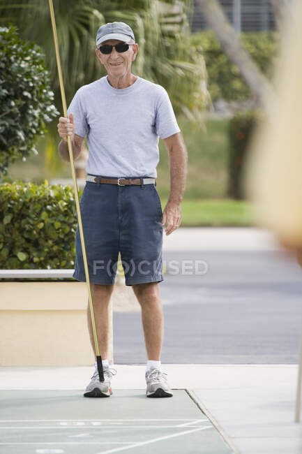 Uomo anziano giocare shuffleboard — Foto stock