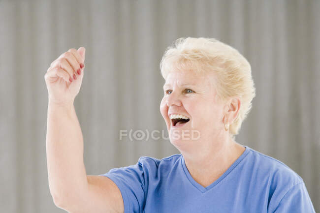 Mujer mayor haciendo ejercicio en un gimnasio y riendo - foto de stock