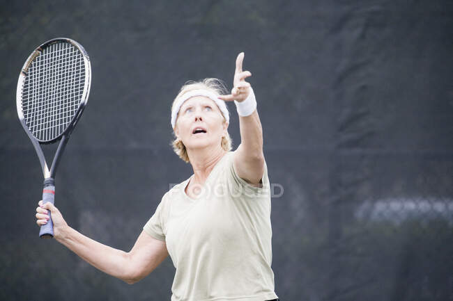 Femme âgée jouant au tennis — Photo de stock