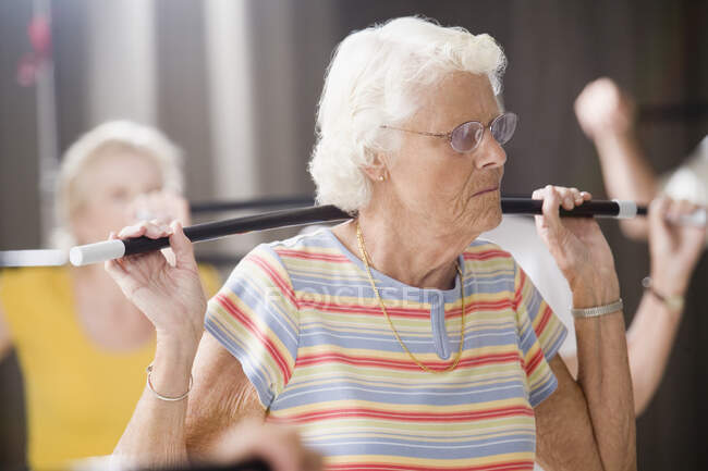 Primer plano de una mujer mayor que ejerce en una clase de ejercicio - foto de stock