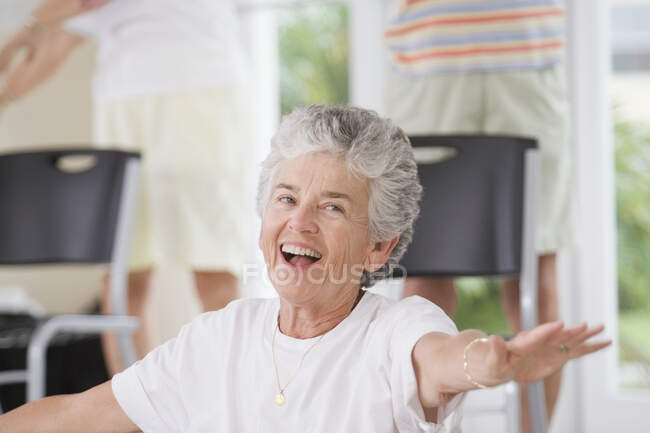 Primo piano di una donna anziana che esercita in una classe di esercizio — Foto stock